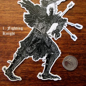 K&ouml;nnte beinhalten: Schwarz-wei&szlig;er Aufkleber eines Ritters in voller R&uuml;stung, mit Schwert und Pfeilen. Der Aufkleber tr&auml;gt den Text "1. Fighting Knight". Ein Lineal und eine M&uuml;nze liegen daneben.