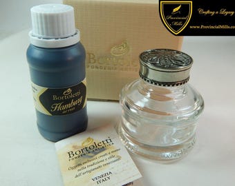 May include: A blue ink bottle labeled Bortoletti Hamburg, a clear glass inkwell with a decorative silver-toned metal lid, a beige cardboard box with the Bortoletti Fonderia Artistica logo, and a small informational card from Venice, Italy.