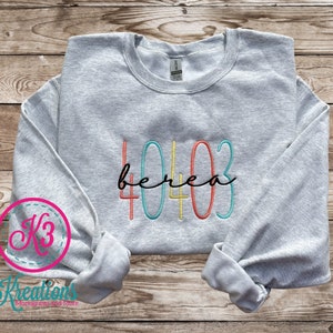 May include: A gray sweatshirt with the text "40403 berea" embroidered in colorful thread. The numbers are outlined in blue, yellow, orange, and red.