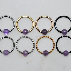 Anillo de AMATISTA con cuentas cautivas, acero quirúrgico/titanio. Tamaño: 16 g/14 g. Color: Plata/Oro/Oro rosa/Negro. Estilo: Liso/Trenzado CBR, piedra preciosa morada.