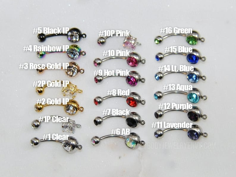 Puede incluir: Una colecci&oacute;n de diecis&eacute;is piezas de joyer&iacute;a corporal tipo barra curva dispuestas en tres columnas. Cada pieza presenta una barra de metal con una bola peque&ntilde;a en un extremo y un engaste de piedra preciosa de color o transparente, numeradas del #1 al #16.