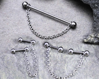 May include: Three silver-toned metal body jewelry pieces, each featuring a straight barbell with spherical ends connected by a delicate link chain. The jewelry displays a polished finish and includes text reading BODYJEWELRYENVY.COM on the surface.