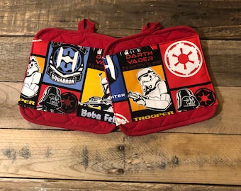 Könnte beinhalten: Zwei rote, gesteppte Topflappen mit Star Wars-Motiv. Die Topflappen zeigen Bilder von Darth Vader, Boba Fett, Stormtroopers und dem imperialen Emblem.