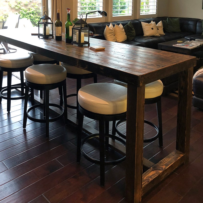 Reclaimed wood bar height table with U-shaped legs and white leather swivel stools, finished in espresso.