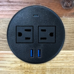 Tabletop power grommet with AC, USB-A and USB-C ports in reclaimed wood.