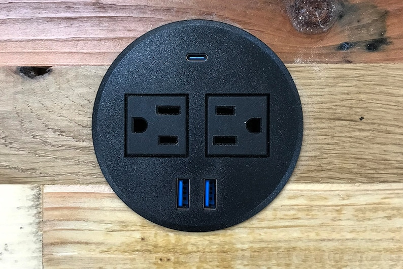 Tabletop power grommet with AC, USB-A and USB-C ports in reclaimed wood.