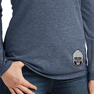 May include: A navy blue long-sleeved hooded shirt with a Buddha face graphic on the right sleeve. The shirt is made of a soft, comfortable material.