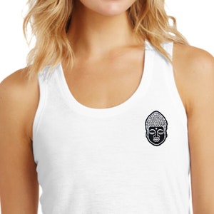 May include: White tank top with a black and white Buddha face graphic on the front. The tank top is made of a soft, comfortable fabric and has a relaxed fit.
