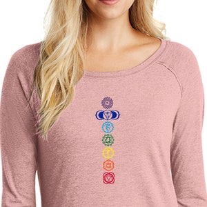 May include: A long-sleeved, pink heather t-shirt with a scoop neck and a design of seven chakras in a vertical line on the front.