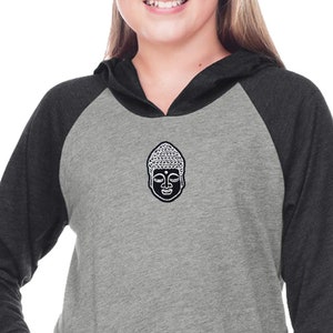 May include: A grey and charcoal hooded sweatshirt with a white Buddha face graphic on the front. The sweatshirt has a kangaroo pocket and long sleeves.