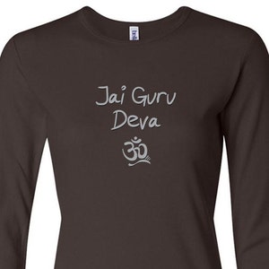 May include: A dark brown long-sleeved t-shirt with the text "Jai Guru Deva" and an Om symbol in a light gray color.
