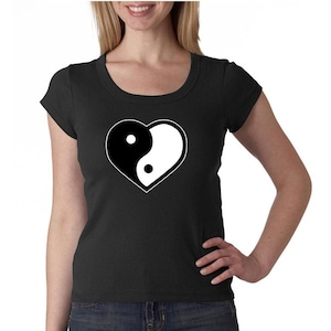 May include: A black t-shirt with a white yin yang symbol in a heart shape.