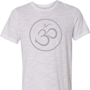May include: White t-shirt with a gray Om symbol in a circle on the front.
