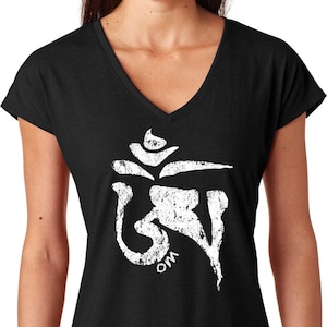 May include: Black V-neck t-shirt featuring a distressed white Om symbol. The Om symbol is a sacred sound and spiritual icon in Hinduism, Buddhism, and Jainism. The shirt is a comfortable, casual wear item.