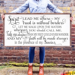 Puede incluir: Un letrero de madera enmarcado con la inscripción en negro "Spirit LEAD ME where MY trust is without borders". El letrero se sostiene frente a una pared de ladrillos. El letrero también incluye el texto "LET ME WALK UPON THE WATERS wherever YOU would CALL ME. Take me deeper THAN MY FEET COULD EVER WANDER AND MY faith will be made stronger in the presence of my Savior."