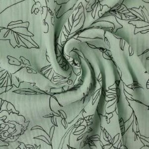 May include: A close-up of a light green fabric with a floral pattern. The fabric has a crinkled texture and is adorned with black outlines of flowers, leaves, and stems. The design is evenly distributed across the material, creating a delicate and artistic look.