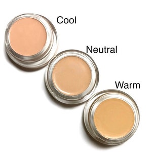 Könnte beinhalten: Drei kleine runde Behälter mit Concealer, beschriftet mit "Cool", "Neutral" und "Warm".