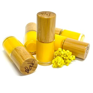 Pu&ograve; includere: Cinque piccoli flaconi di smalto per unghie giallo con tappi in bamb&ugrave;. I tappi sono incisi con la parola "fab".