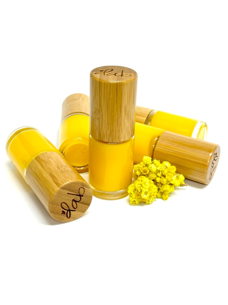 Pu&ograve; includere: Cinque piccoli flaconi di smalto per unghie giallo con tappi in bamb&ugrave;. I tappi sono incisi con la parola "fab".