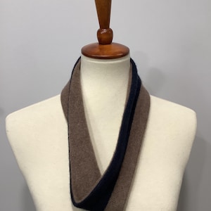 May include: A brown and black striped infinity scarf made of soft knit fabric.