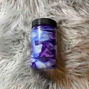 May include: A purple and white swirl design tumbler with a black lid.