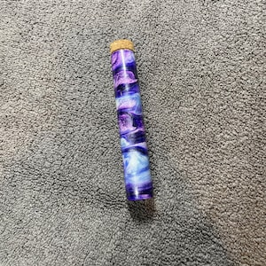 May include: A purple and blue swirl resin tube with a cork top.