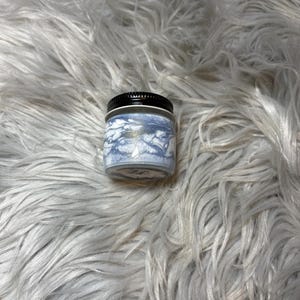 May include: A white ceramic mug with a black handle and the text "But First, Coffee" in a handwritten style. The mug is on a white surface. The mug is 4 inches tall.
