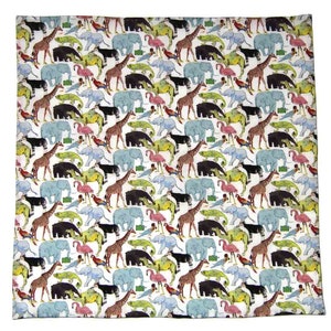 May include: White square fabric with a repeating pattern of various animals, including giraffes, elephants, flamingos, and bears. The animals are in shades of brown, blue, pink, and green, set against a white background. The fabric appears to be cotton or a similar material.
