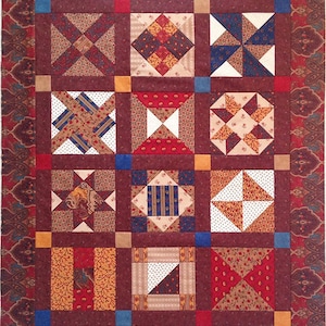 Może przedstawiać: Kołdra w patchworku z różnymi kolorami i wzorami, w tym czerwonym, brązowym, niebieskim i białym. Kołdra składa się z dziewięciu kwadratów, każdy z innym wzorem. Kołdra nosi tytuł "Dixie Dairy by Stitch & Knit".