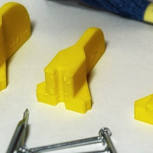May include: Three yellow plastic pieces with the word "LEGO" printed on one of the pieces.