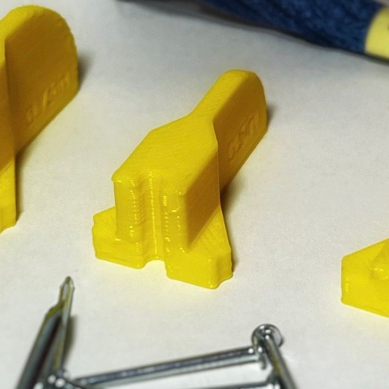 May include: Three yellow plastic pieces with the word "LEGO" printed on one of the pieces.