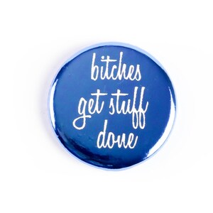 May include: A blue round button with the text "bitches get stuff done" in white.