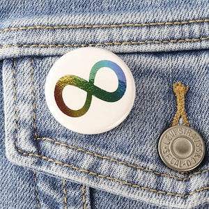 Op de afbeelding: Een regenboog oneindigheidssymbool pin op een blauw denim jack.