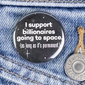 May include: A black and white button with the text "I support billionaires going to space. (as long as it's permanent.)" on a denim jacket.