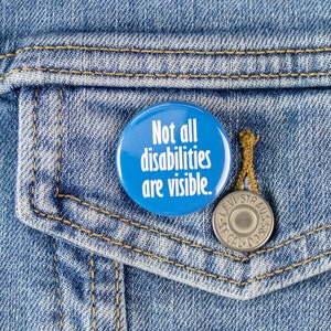 May include: A blue button with the text "Not all disabilities are visible." on a denim background.