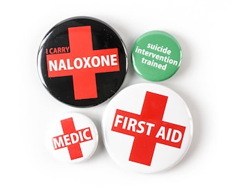 PAQUETES MÚLTIPLES: Botón de primeros auxilios, insignia de médico, botón Llevo naloxona y botón de entrenamiento en intervención suicida. ¡Usa tus habilidades!