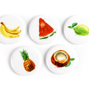 May include: Five round white coasters with watercolour illustrations of tropical fruits. The coasters feature a banana, watermelon, lime, pineapple, and coconut.