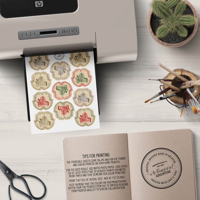 May include: Printable sheets of whimsical Christmas gift tags featuring a reindeer, a tree, and a house with a red roof. The tags are printed on a beige background with a distressed look. The text on the sheet reads "Tips for Printing" and includes instructions for printing the tags. The text on the bottom right corner reads "Original Designs Made in Belgium, Premium Quality, Whimsical Adventure, Created with Love & Care".