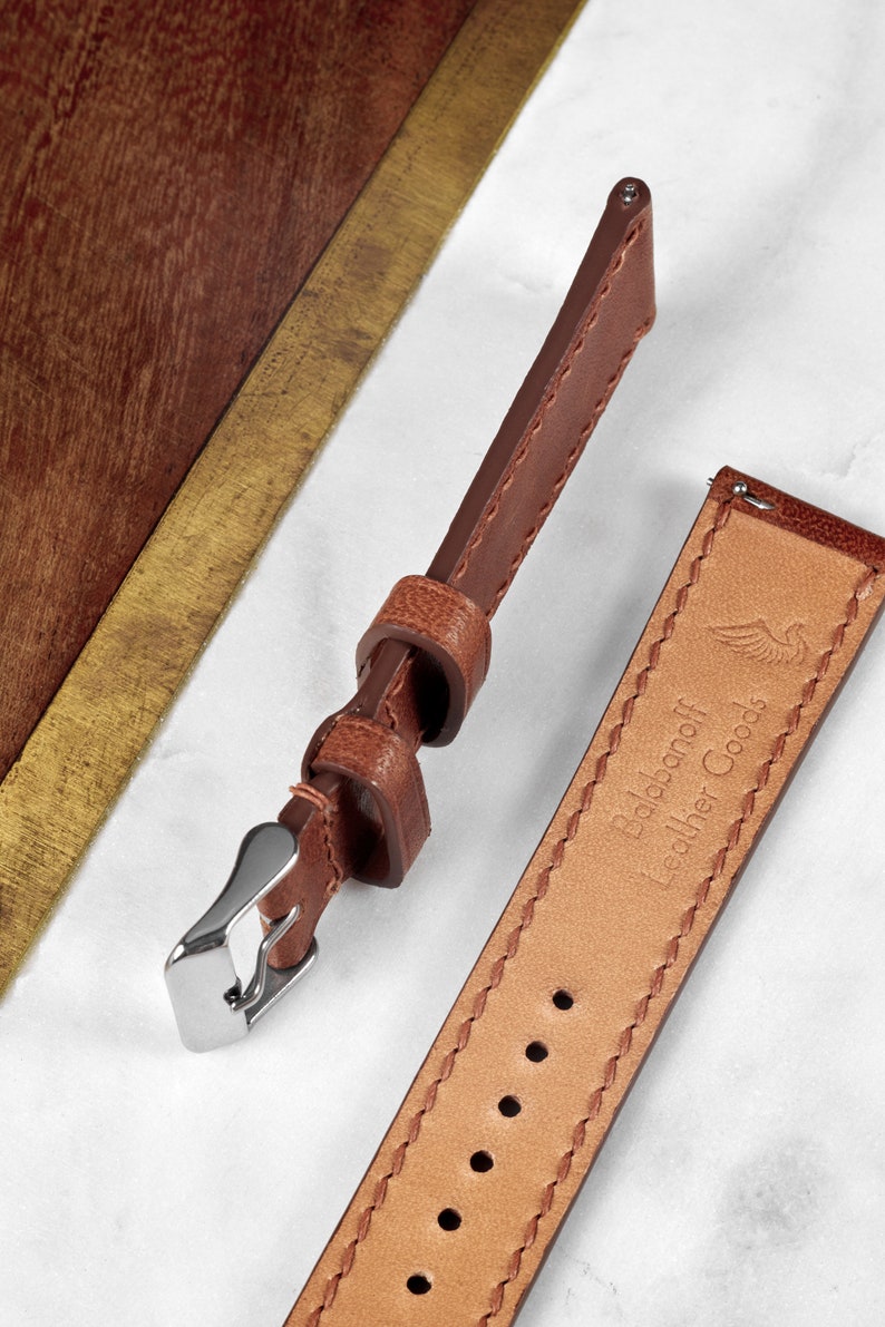 May include: Two brown leather watch straps with stitching detail. One strap has a silver buckle and the other has the text "Dalbanoff Leather Goods" embossed on it.