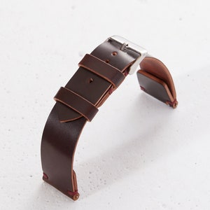 May include: A brown leather watch strap with a silver buckle. The strap has red stitching and is designed for a watch with a 20mm lug width.