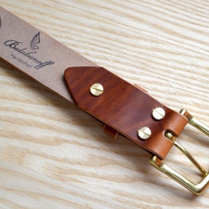 Puede incluir: Un cintur&oacute;n de cuero marr&oacute;n con una hebilla de lat&oacute;n. El cintur&oacute;n tiene una etiqueta de cuero Horween con el texto "Balabanaoff Handcrafted".