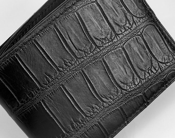 May include: A black leather wallet with a crocodile embossed pattern.