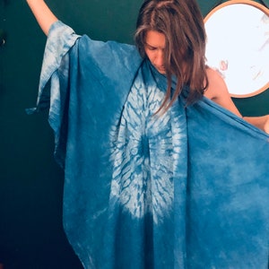 May include: A person wearing a blue tie-dye kimono with a white circle design in the center.