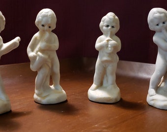 Four Vintage Unsigned White With Black Eyes Ceramic Standing Figurines Playing Musical Instruments, Saxophone, Guitar, Trombone, French Horn