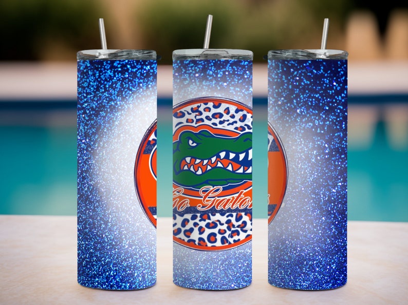 May include: Three stainless steel tumblers with blue glitter finish. The center tumbler features a white and orange circle with a green alligator and the text "Go Gators".