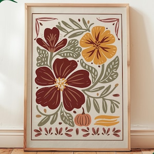 May include: A framed art print with a floral design in burgundy and yellow, with green leaves and a pumpkin illustration. The print is set against a cream background and framed in light wood. The words "DIGITAL DOWNLOAD" and "SHOP Greenhouse STUDIO" are also visible.