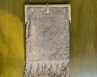 Peut inclure: Un sac à main vintage en maille dorée avec une bandoulière chaîne et un bas à franges.