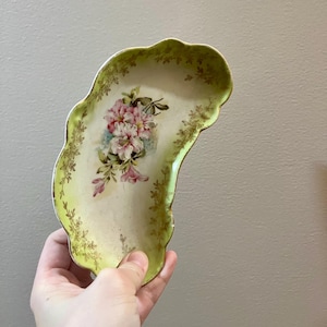 Plato de porcelana con forma de medialuna y flores pintadas a mano