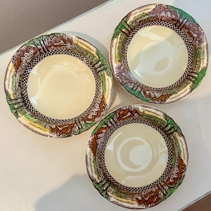 May include: Three vintage ceramic bowls with a brown, green, and white checkered pattern. The bowls have a cream-colored interior and a rim with a green and brown floral design.