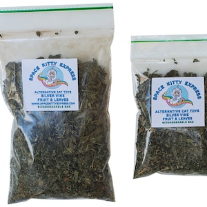 May include: Two clear plastic bags with green dried leaves inside. The bags have labels that say "Space Kitty Express" and "Alternative Cat Toys Silver Vine Fruit & Leaves Biodegradable Bag".